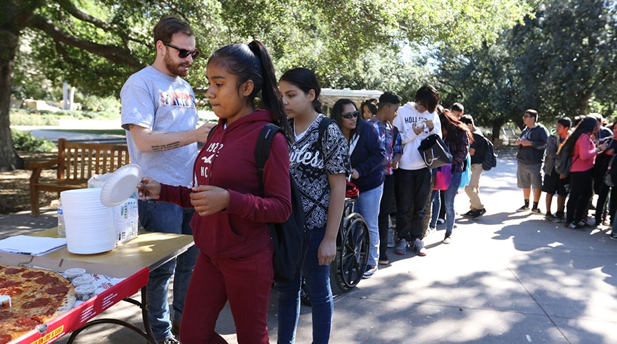 Elementary school students on the Occidental College campus lining up for pizza
