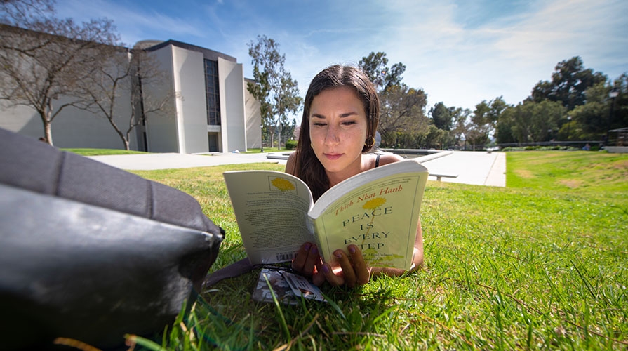 student reading on campus