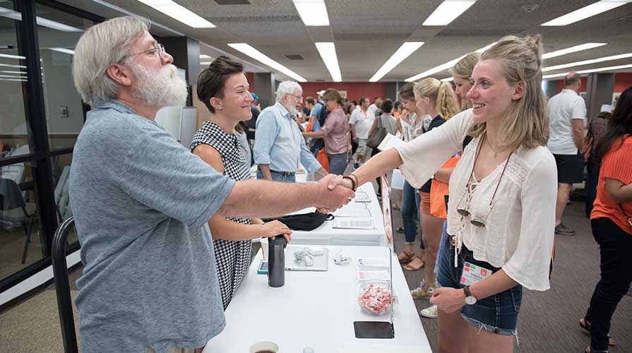 A professor talks to a student at Orientation