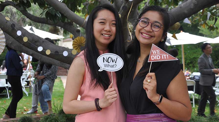 Two students pose at graduation