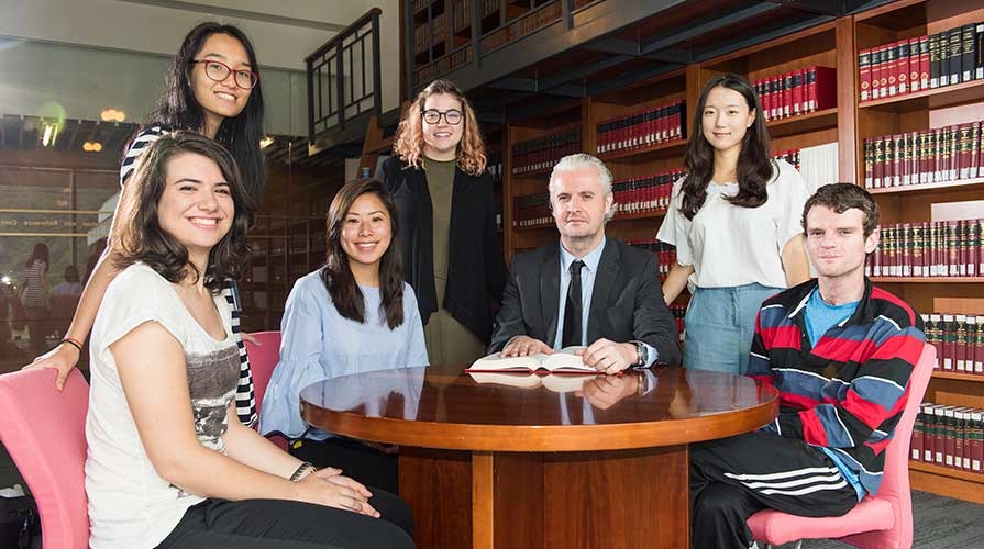 Students pose with an administrator at a foreign university