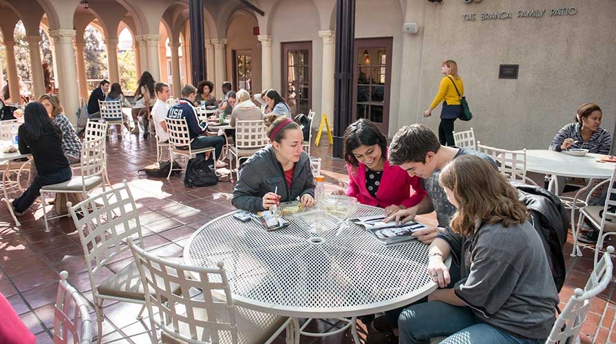 Students sitting together at a table on Branca Patio