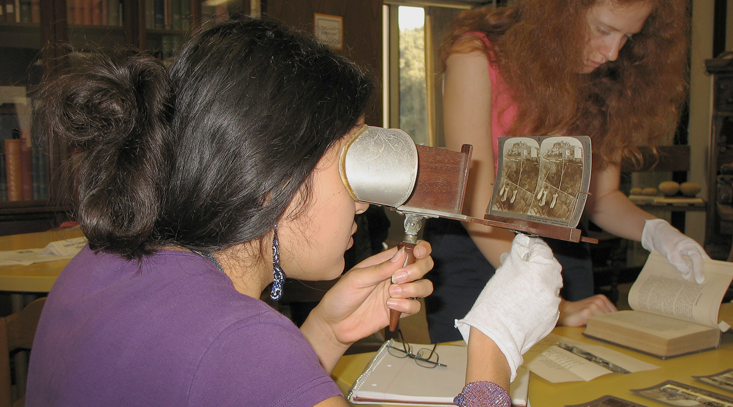 An Occidental (Oxy) student using an antique stereoscope to view a stereograph card