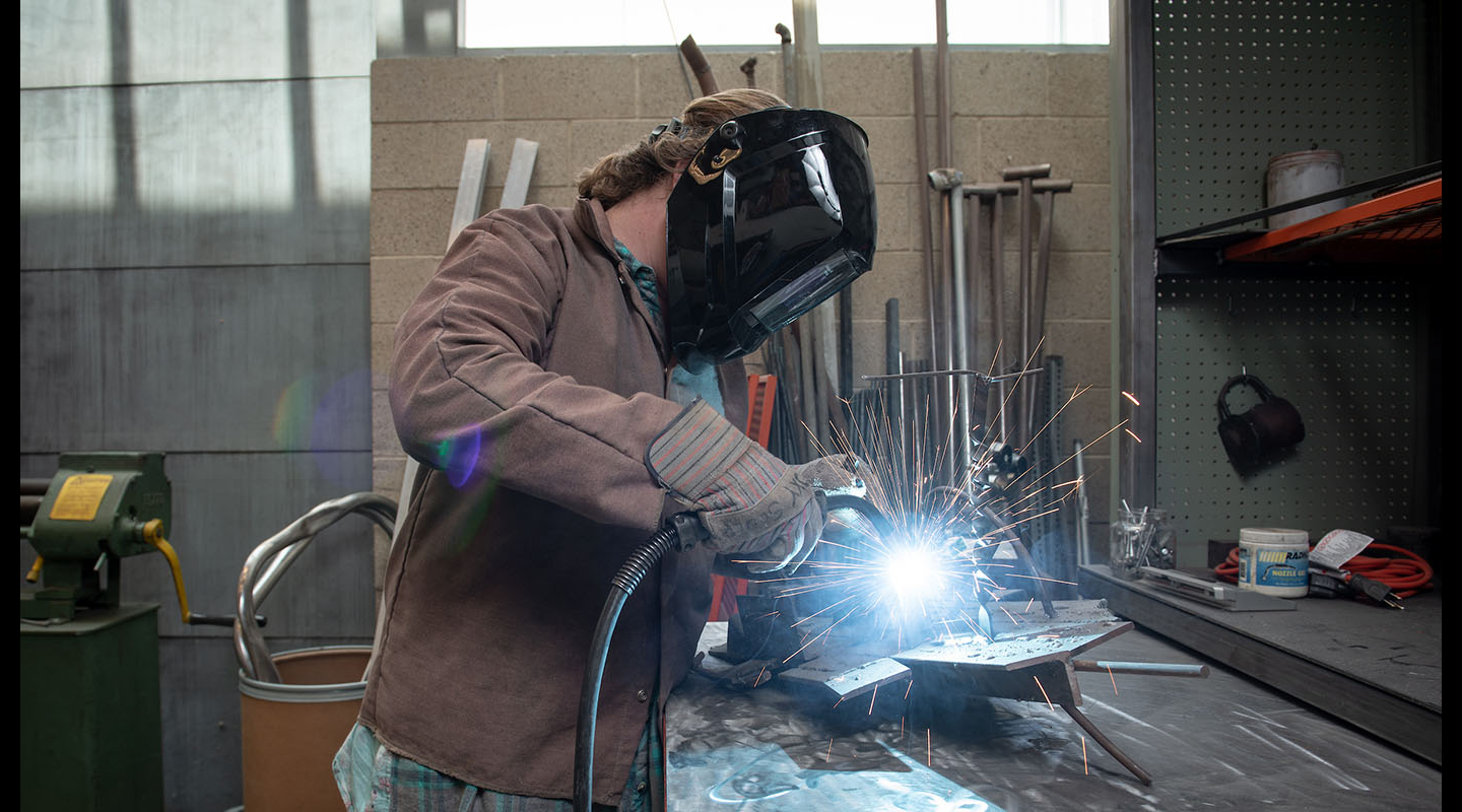An Occidental (Oxy) student welding in a workshop