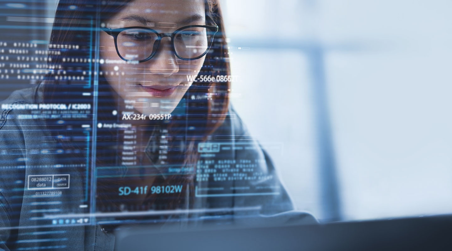 a young woman smiling as she looks at a large computer screen full of data illustration