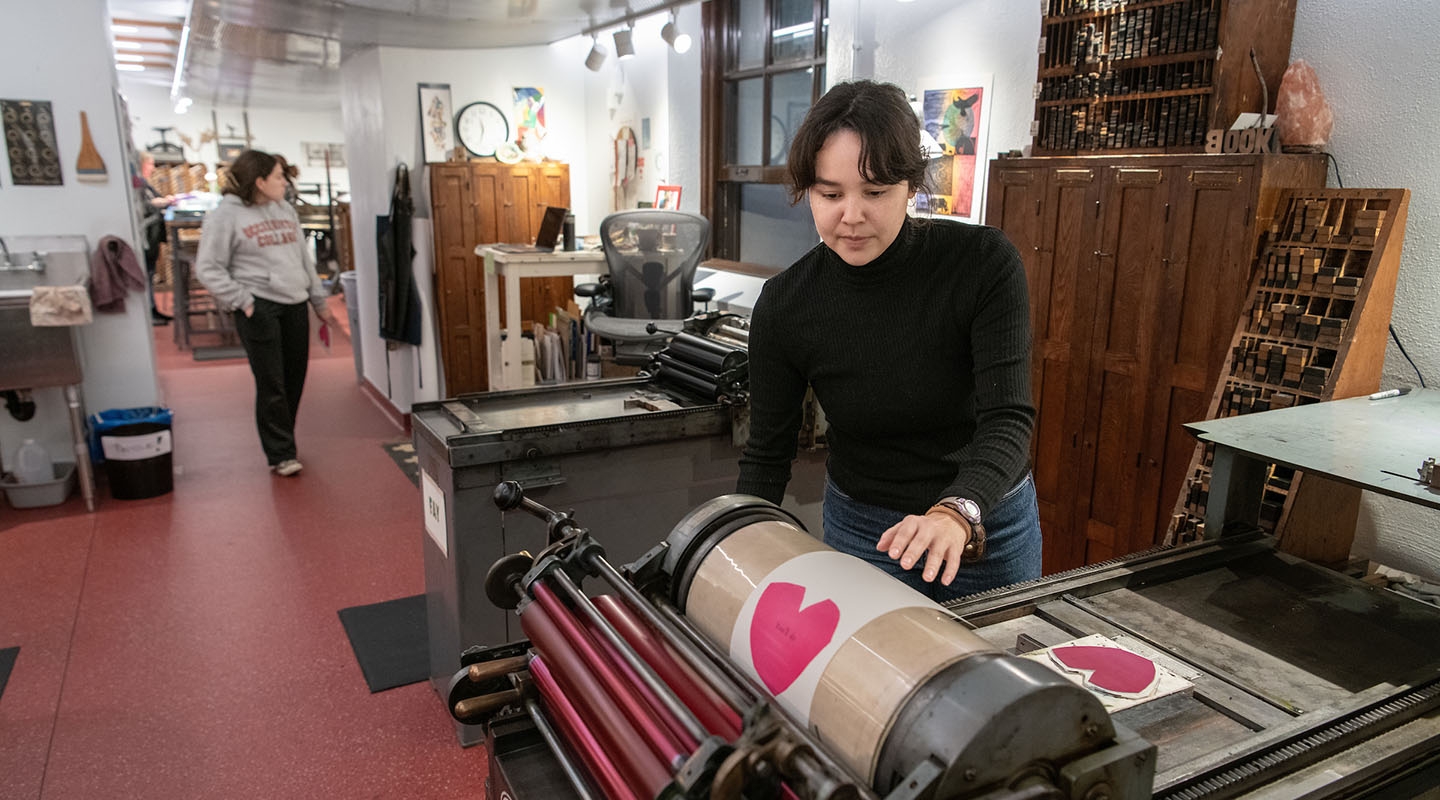 An Occidental College student printing a card at the Lowercase letterpress print shop in the library on campus