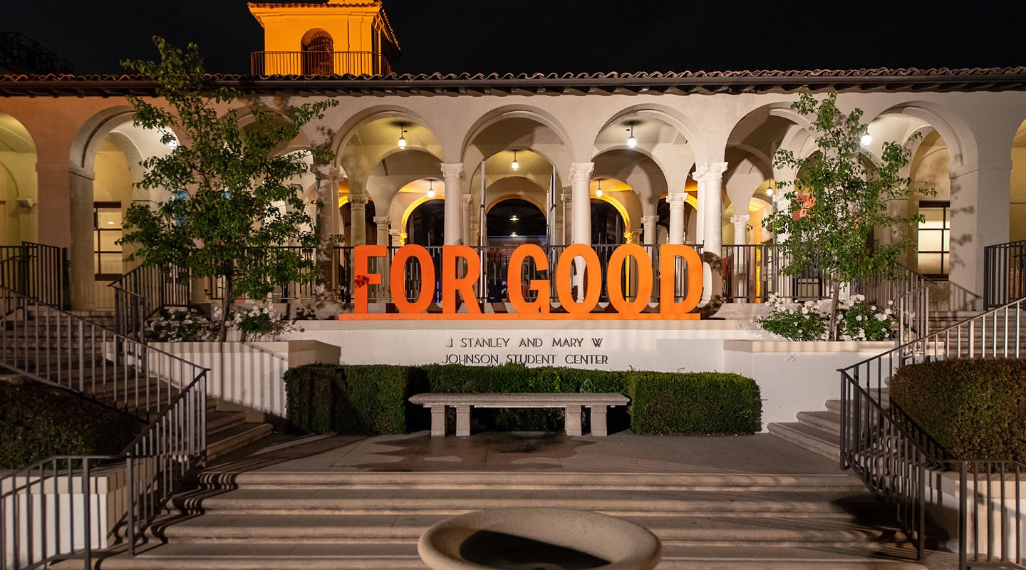 A shot of the Johnson Student Center south entrance with a fountain and the 3-D letters For Good assembled