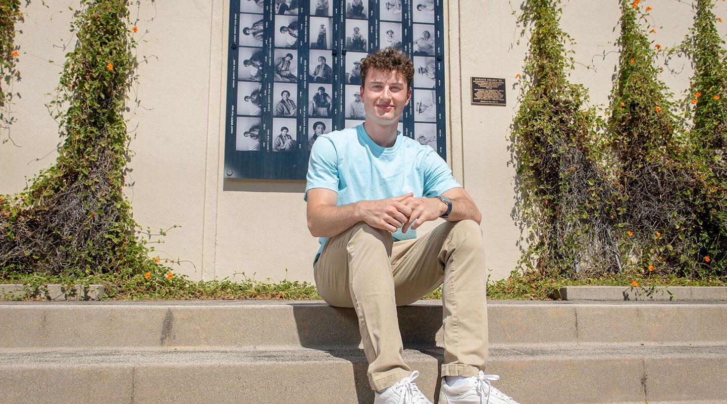 James Steinberger '25 sits on the steps in front of Haines Hall with a blue shirt.