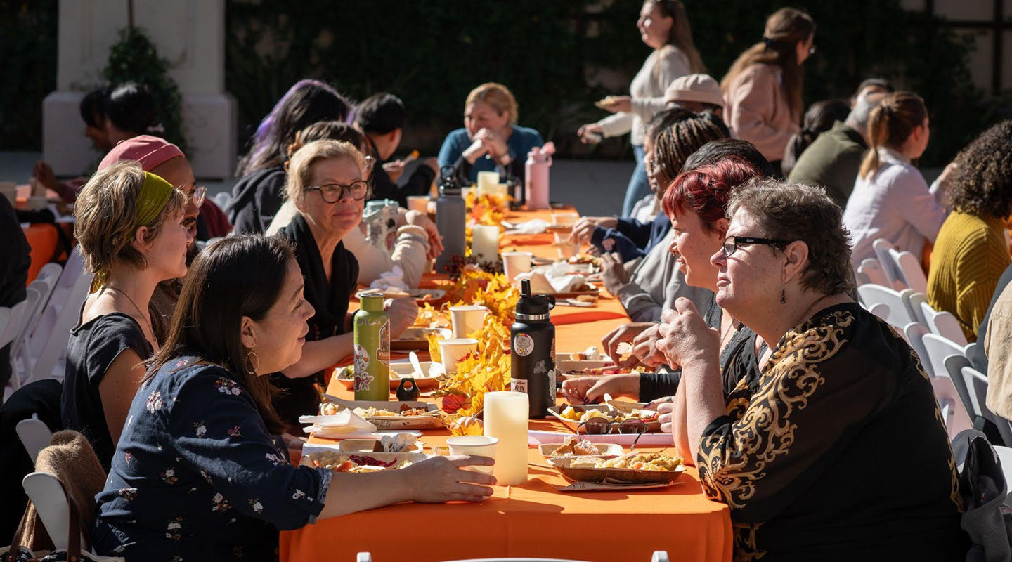 Occidental College staff members sitting together at a picnic table, talking