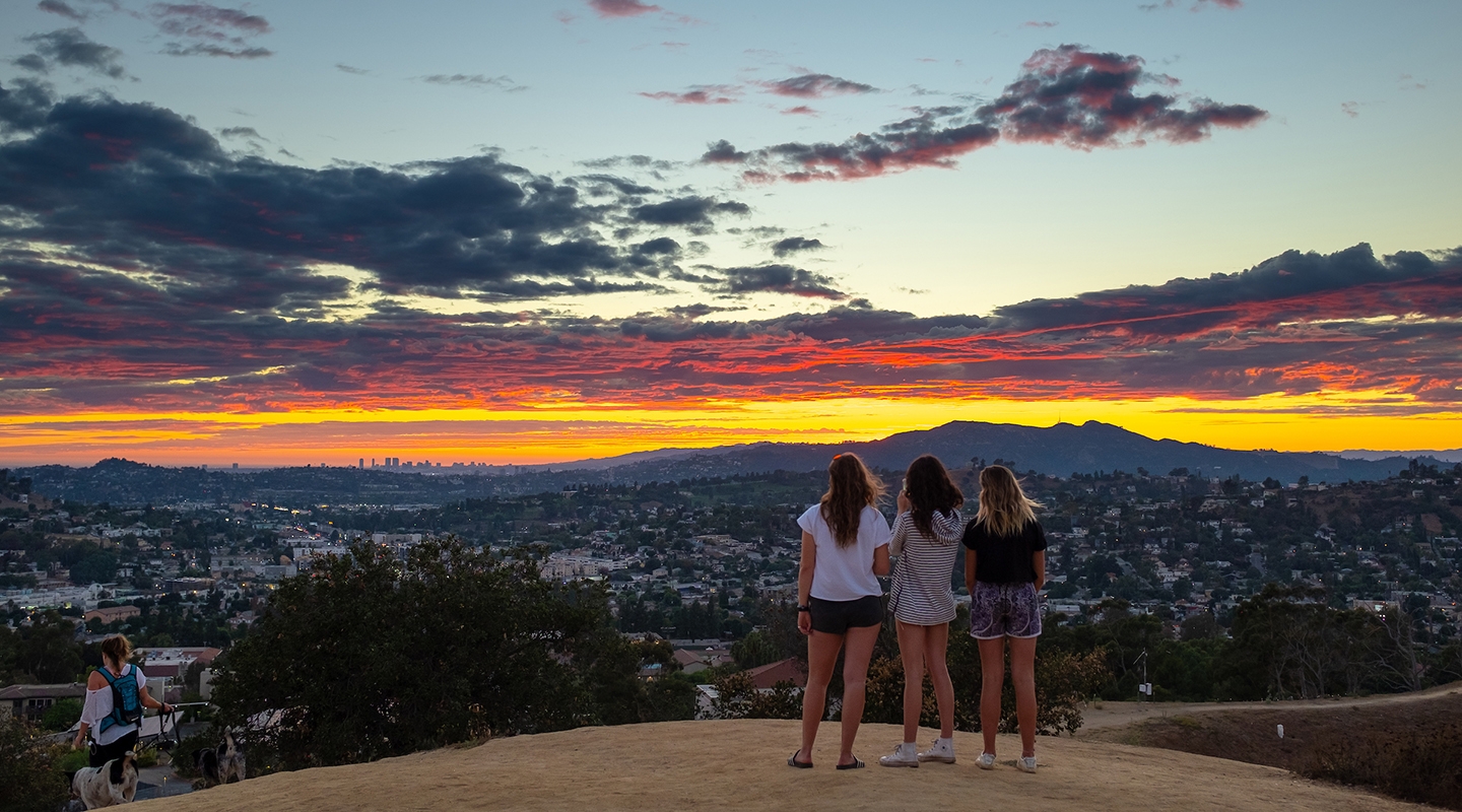 Students standing on Fiji Hill at sunset