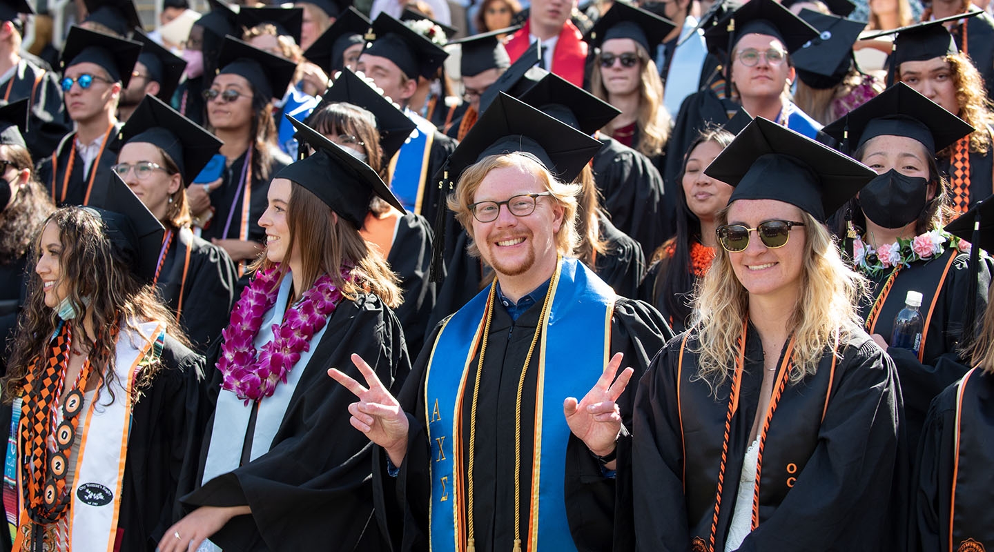 graduates smiling and posing at the 2022 commencement ceremony