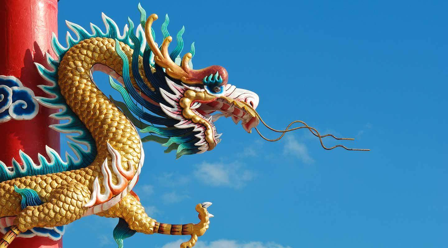 large, golden Chinese dragon sculpture, likely a decoration on a temple or building. 