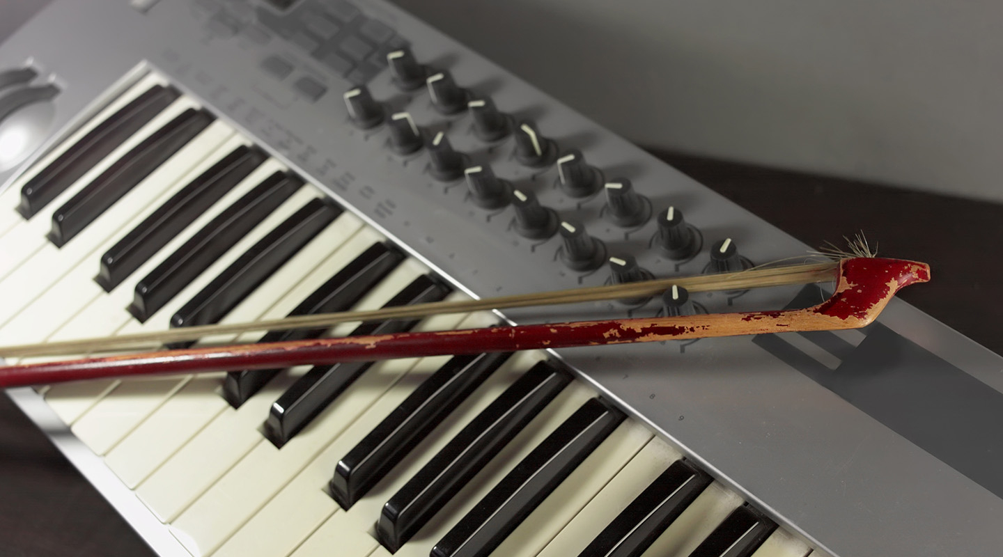 an electronic keyboard controller with a violin bow resting on its keys