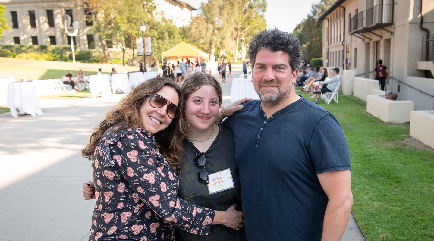 A student embracing her parents