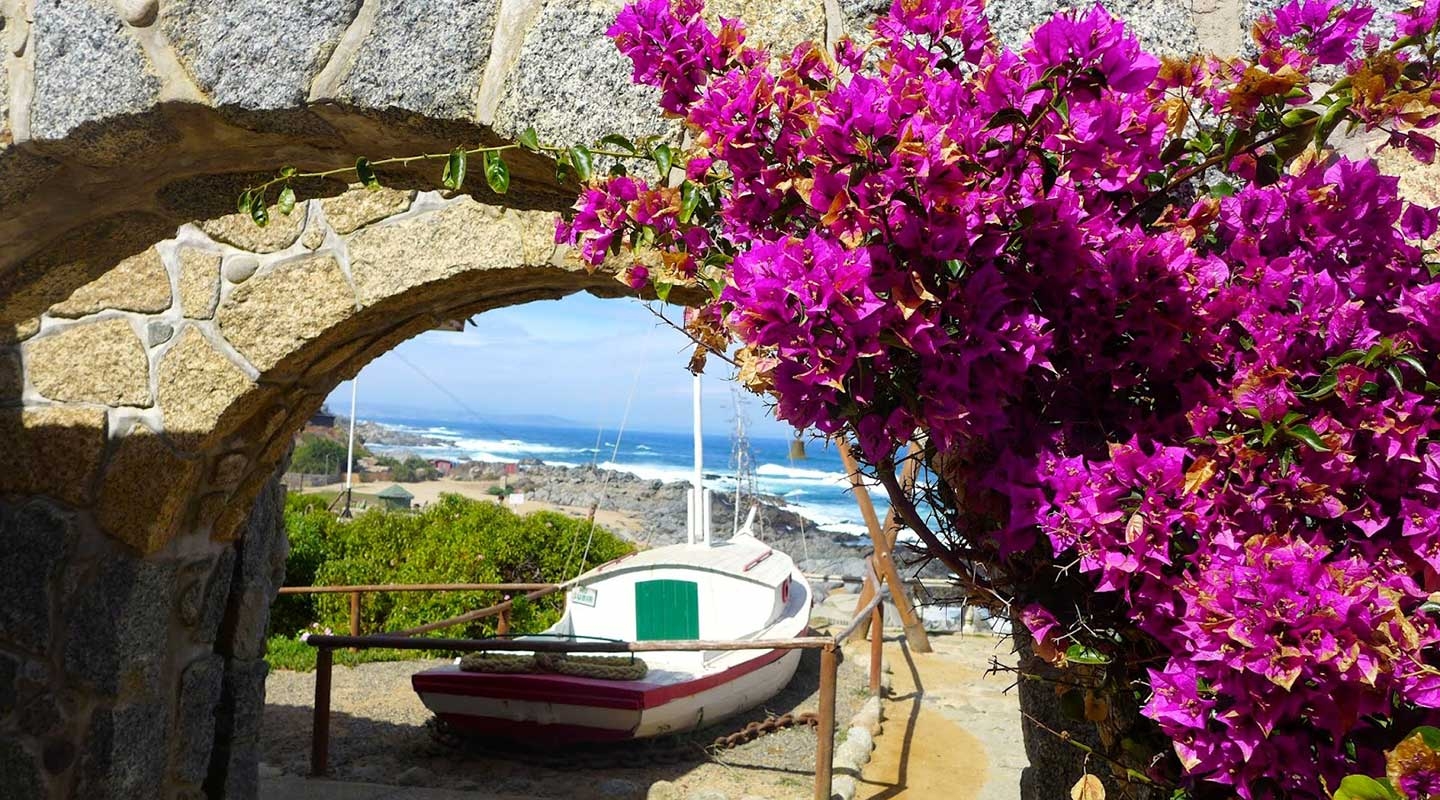 A sailboat on a beach next to the ocean