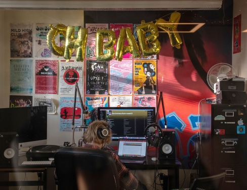 a student in the dj booth at the KOXY radio station