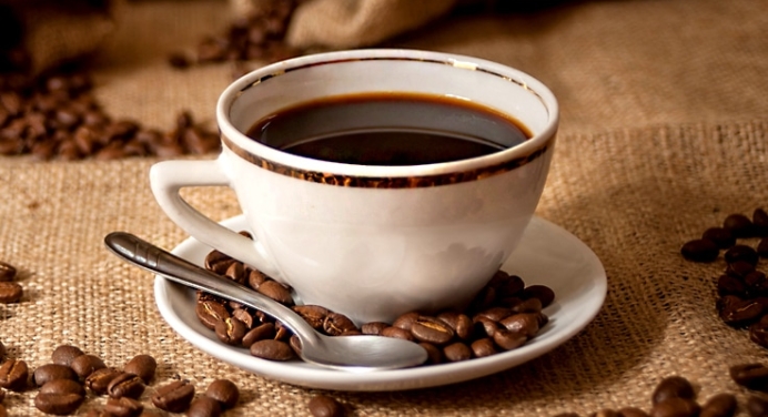 a hot cup of coffee in a porcelain coffee cup with spoon