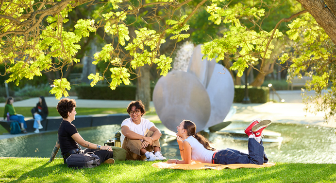 Occidental students sit on the lawn near the Gilman Fountain