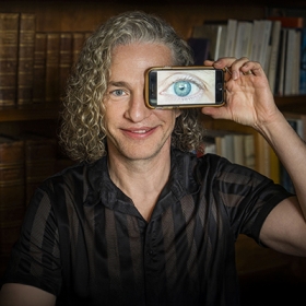 Occidental College professor Broderick Fox holding a cameraphone up to his eye