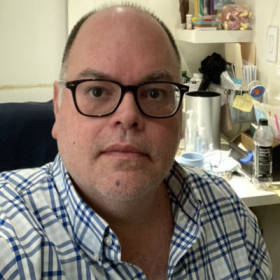 Man in front of shelf