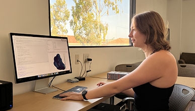 a young woman looking at a computer with data