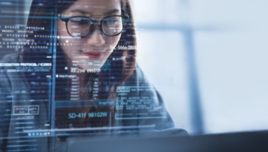a young woman smiling as she looks at a large computer screen full of data illustration
