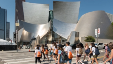Occidental College students walking across Grand Avenue in LA to the sculptural Disney Concert Hall