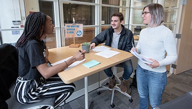 Two writing tutors talk to writing center administration