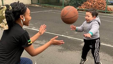 Student Darla Howell plays basketball with a Chinese toddler
