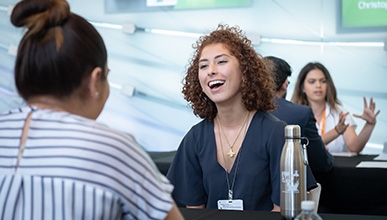 Two students chat at a table during Career Fair