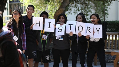Gear Up students hold a sign that reads "History"
