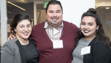 Three smiling students attend admission event