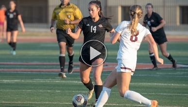 Soccer player in black jersey kicks ball