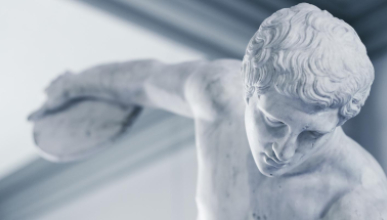 An ancient Greek or Roman sculpture of a man with his arm stretching back to throw a discus, representing the Classical Studies program at Occidental College (Oxy).