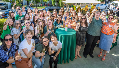 Members of Delta Omicron Tau spannng five decades raise a glass at the Delta House one last time on October 19.