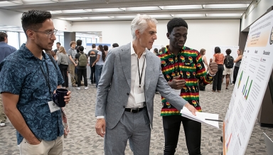 Assistant Professor of Chemistry Raul Navarro and President Stritikus discuss cognitive science major Stephen Sekyere '28's research at Occidental's Summer Research Program Conference on July 30. 