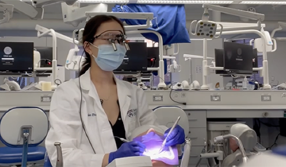 Occidental College alumna Annie Zhou working in a dentistry office on a patient