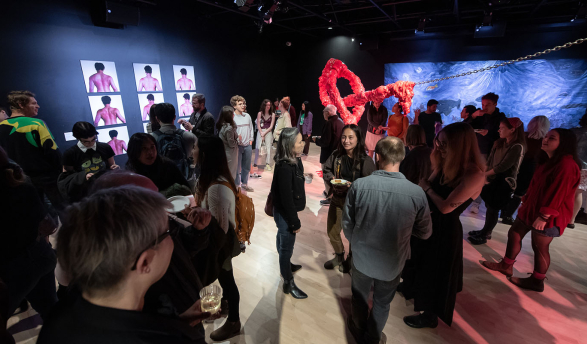 a dim, crowded gallery space at an Oxy Arts exhibition, Occidental College