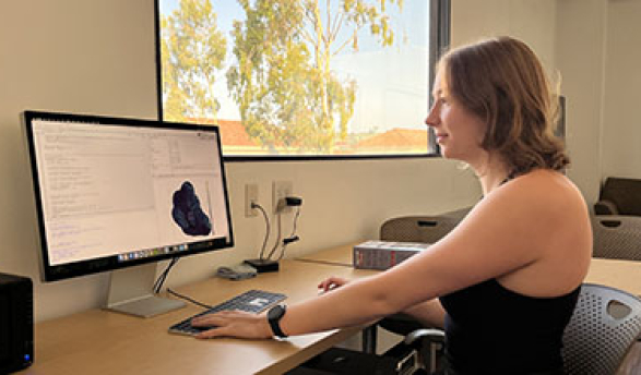 a young woman looking at a computer with data