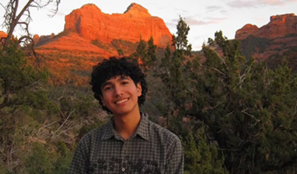 Emri Espinoza headshot with alpineglowing desert mountains in the background