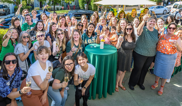 Members of Delta Omicron Tau spannng five decades raise a glass at the Delta House one last time on October 19.