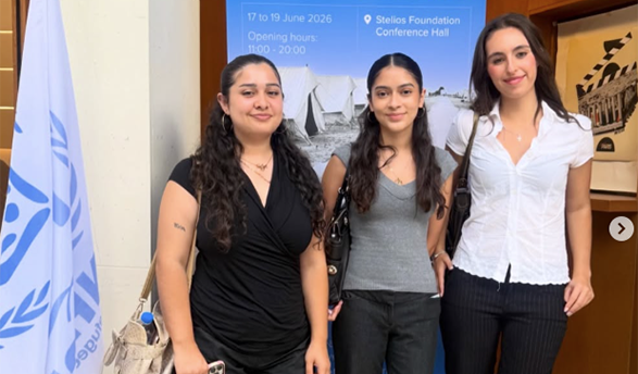 Three Occidental students in front of a flag