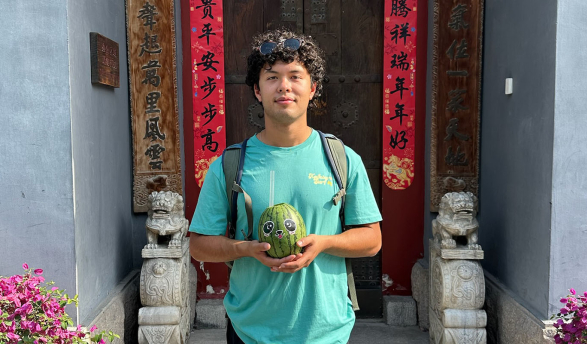 An Occidental College student in front of a doorway in China