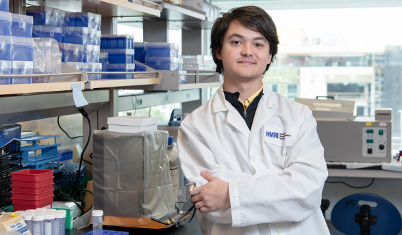 An Occidental College student in a white coat in the science lab