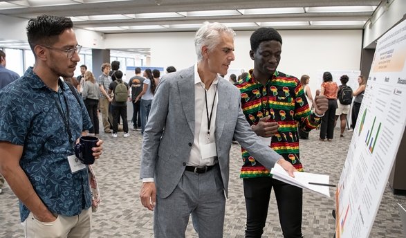 Assistant Professor of Chemistry Raul Navarro and President Stritikus discuss cognitive science major Stephen Sekyere '28's research at Occidental's Summer Research Program Conference on July 30. 