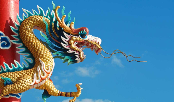 A large, golden Chinese dragon sculpture, likely a decoration on a temple or building. 