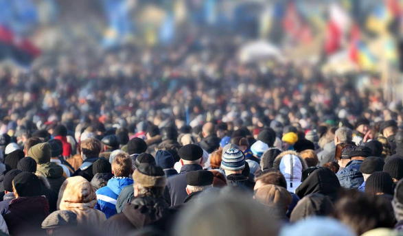 rear view of a large crowd of people viewing international flags
