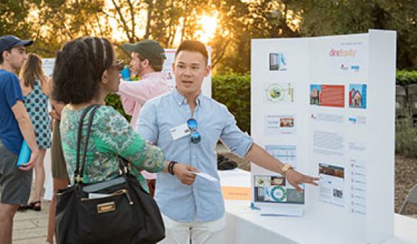 Student gestures to presentation board as he explains InternLA experience