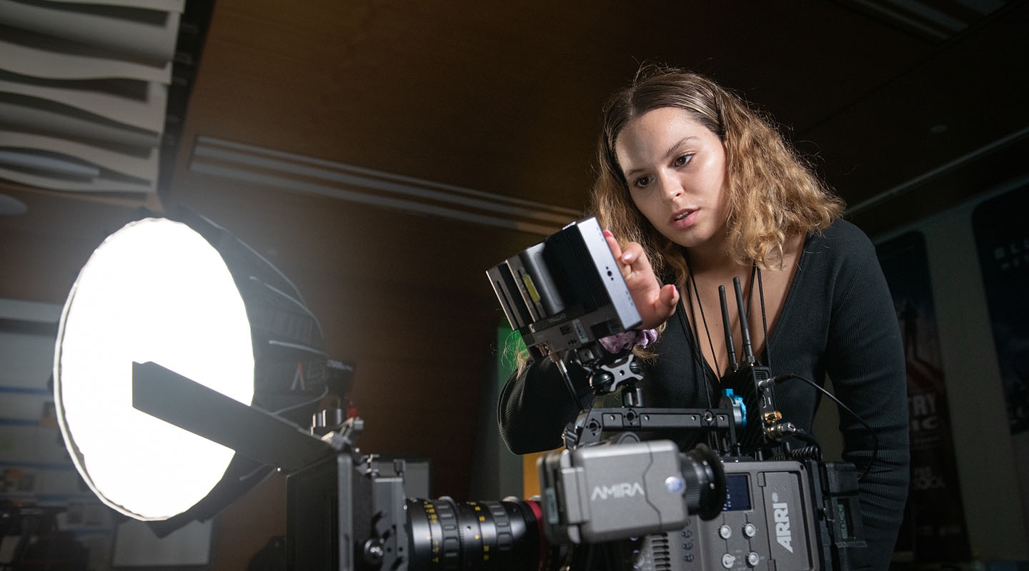 a student working with a sophisticated television camera