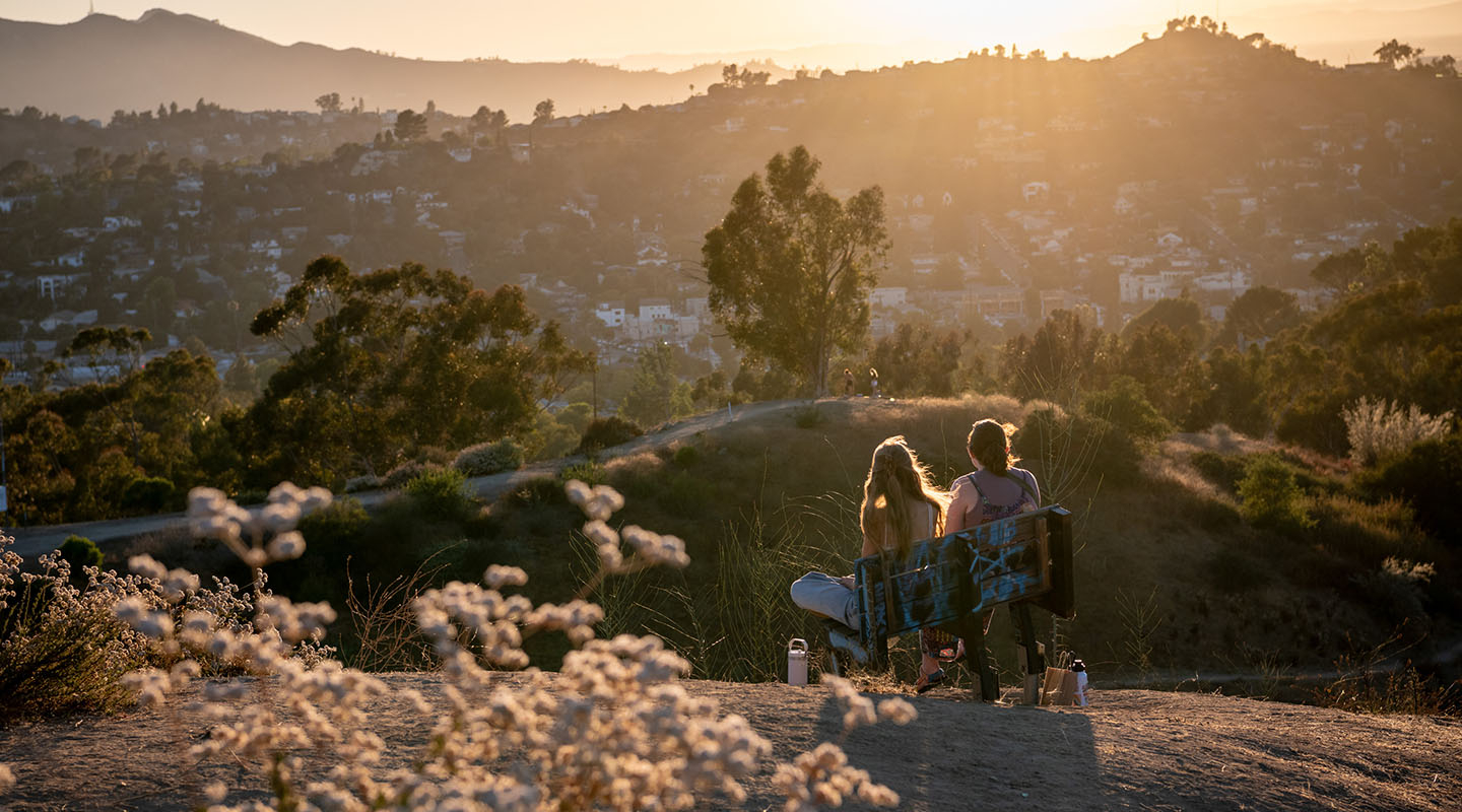 two Occidental students in a late afternoon sun-drenched scene on top of Fiji Hill at sunset